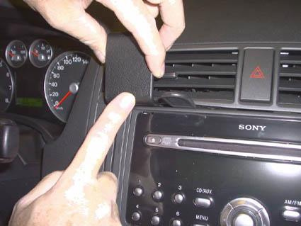 En person pekar på en bils luftventil och stereo.