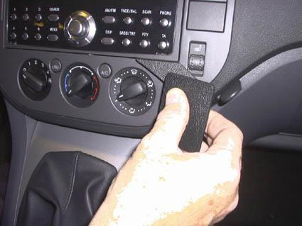 En hand justerar en ratt eller reglerare på en bils instrumentpanel.