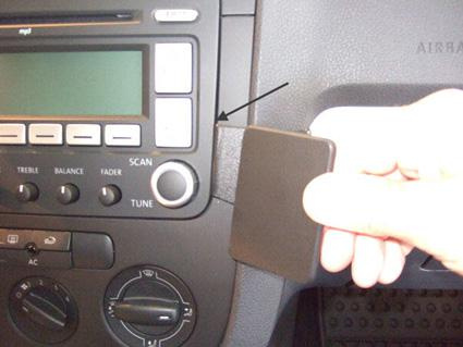 En hand som drar en platta från en bils instrumentpanel.