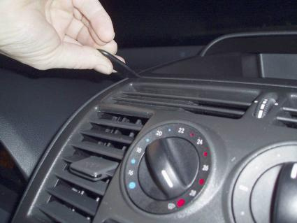 En hand justerar inställningarna på ventilationssystemet i en bil.