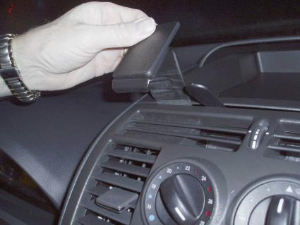 En hand placerar en del på en bils instrumentbräda.