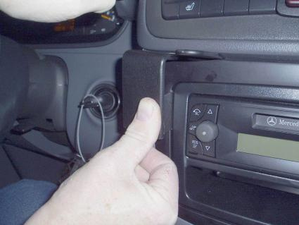 En hand justerar en del av bilens instrumentbräda.