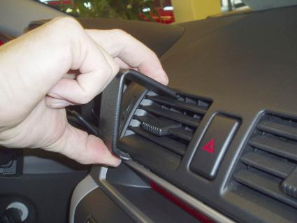 En hand justerar en luftventil i en Mazda 3 interiör.