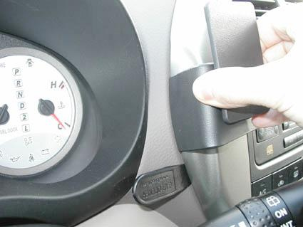 En hand justerar en knopp på bilens instrumentbräda.