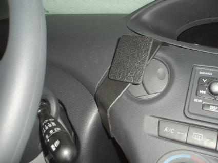 En svart plastfäste monterat på instrumentbrädan, nära luftutloppet.