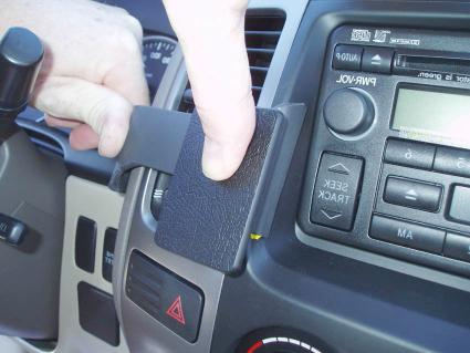 En hand monterar en ProClip på en Toyota LandCruiser 90:s instrumentpanel.