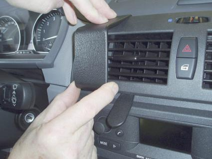 En person installerar en del på instrumentbrädan i en BMW X3.