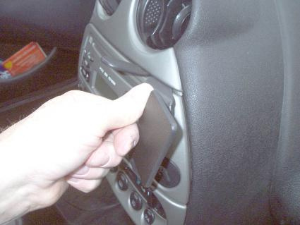En hand som trycker på en knapp i en bilinteriör.