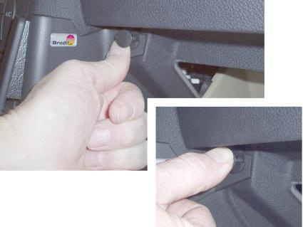 Hand som trycker på en knapp i en bils interiör.