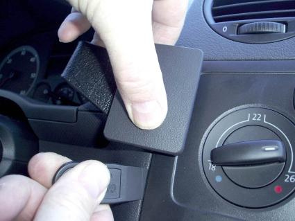 En hand justerar en kontrollpanel i en Volkswagen Caddy.