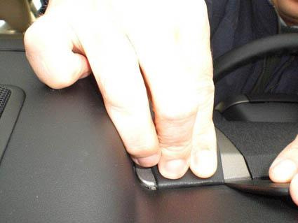 En hand justerar eller installerar en del på Toyota Prius 04-09.