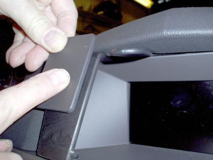 En hand placerar en komponent i en Opel Astra från 2004-2009.