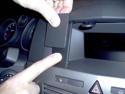 En person pekar på en del av instrumentbrädan i en Opel Astra.