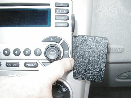 En hand trycker på en knapp på en bilradio i en Chevrolet Equinox.