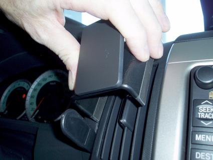 Hand som justerar en del av instrumentpanelen i en Toyota Corolla Verso.