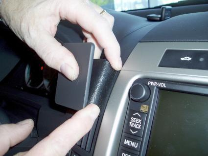 En hand justerar en del av bilens instrumentbräda.