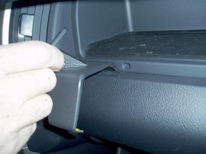 En hand som hanterar en del av instrumentpanelen i en Toyota Corolla Verso.