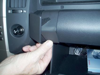 En hand öppnar handskfacket i en Toyota Corolla Verso.