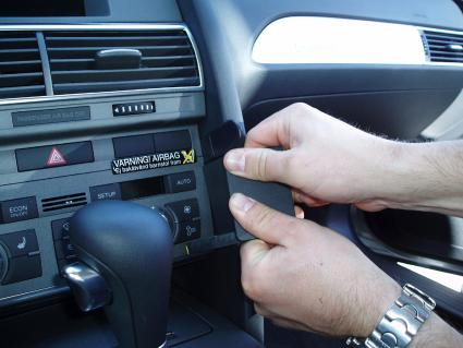 En person monterar en del i en Audi A6 inredning.