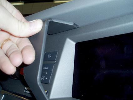 En hand som pekar på en del av instrumentpanelen i en Audi A6 04-09.