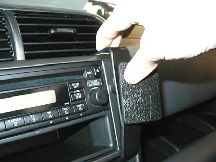 En hand tar bort en del av instrumentpanelen i en Honda Element.