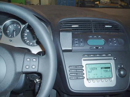 Bilden visar ett bilinteriör med instrumentbräda och radio.