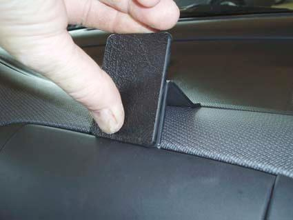 En hand håller en svart plastdetalj för Nissan Micra 03-10.