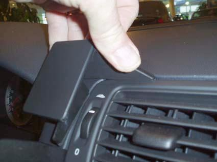 Hand som justerar en panel nära luftutloppet på en Volvo S40.