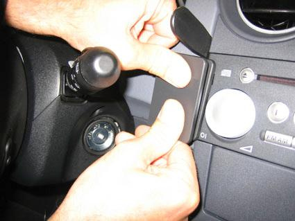 En hand justerar en del av en bils instrumentbräda.