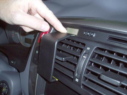 En hand pekar på en del av bilens ventilationssystem.