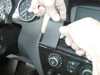 En person installerar en monteringsbygel i bilens instrumentpanel.