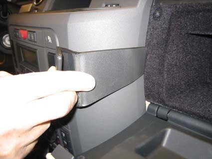En hand trycker på en del av interiören i en Landrover Discovery.