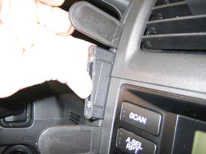 Del av bilens instrumentbräda med hand som justerar en komponent.