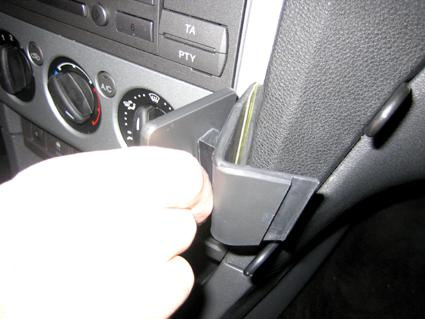 En hand för in något i en vinklad hållare på Ford Focus interiör.