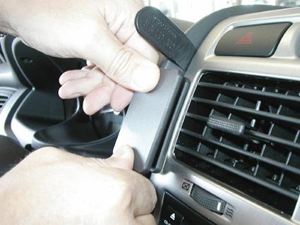 Två händer justerar en del av bilens inredning.