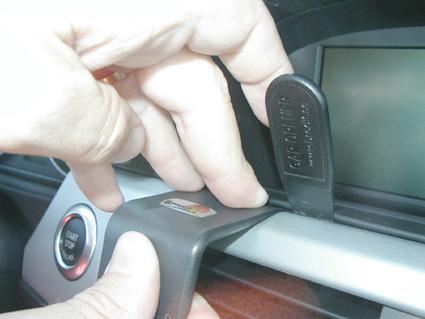 En hand justerar en del av bilens navigationssystem.