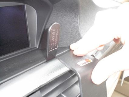 En hand justerar en komponent på instrumentbrädan i en BMW.