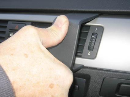 En hand justerar en del av interiören i en BMW E90/E91/E92/E93.