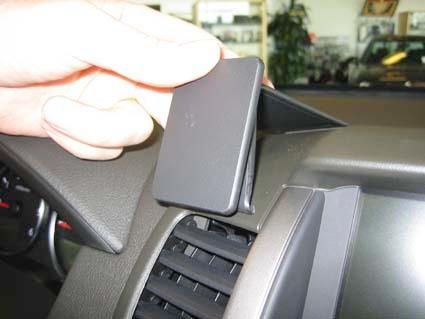 Ett handgrepp tar bort en panel från instrumentbrädan på en Nissan Navara.