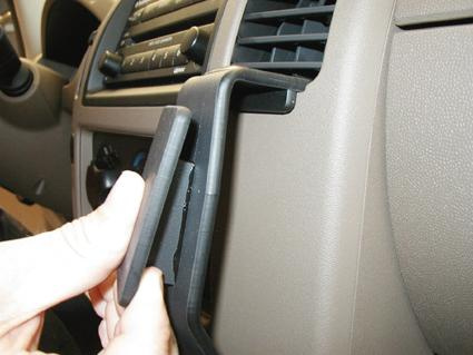 En person installerar en del i interiören på en Nissan Navara.