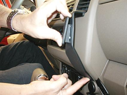 En person installerar en del på instrumentbrädan i en Nissan Navara.