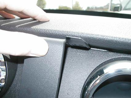 En hand visar en del av instrumentpanelen i en Ford Mustang 05-09.