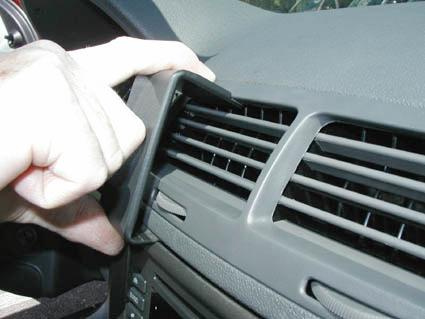 En hand justerar luftutloppet i en Chevrolet Cobalt 05-10.