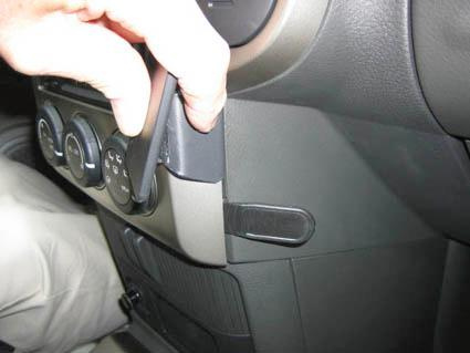 Bild visar en hand som justerar en del av instrumentpanelen i en Nissan X-Trail.