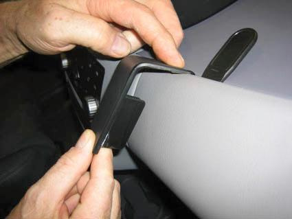 En hand håller en svart monteringsbygel för Nissan Almera Tino.