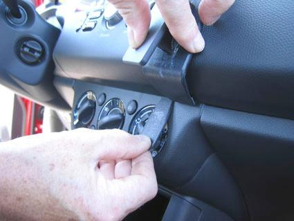 Hand som justerar kontroller på instrumentbrädan i en Suzuki Swift 05-10.