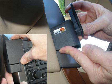 En hand monterar en hållare i en bilinteriör.