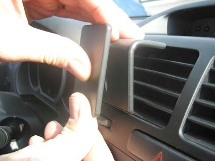 En person placerar en del på bilens luftventil.