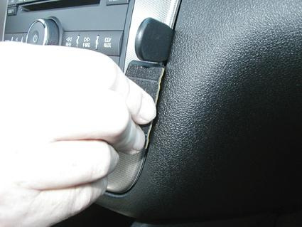 En hand justerar en del på instrumentbrädan i en Chevrolet Impala 06-13.