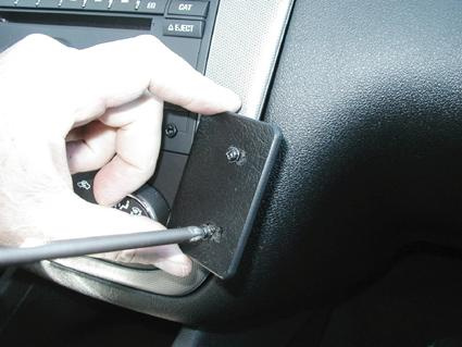 En hand installerar en vinklad komponent på instrumentpanelen i Chevrolet Impala.